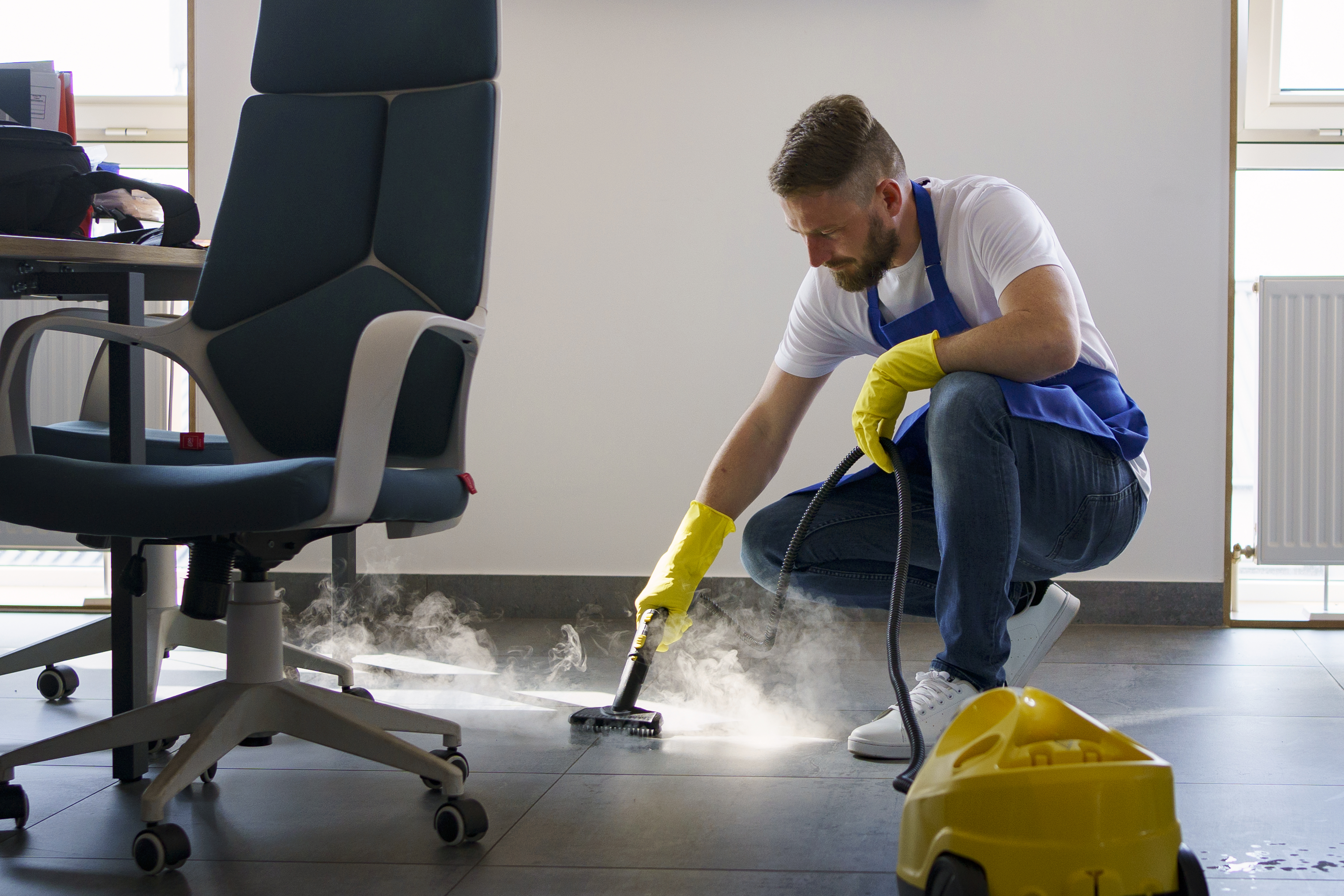 Technician steam cleaning carpet in a Denver office
